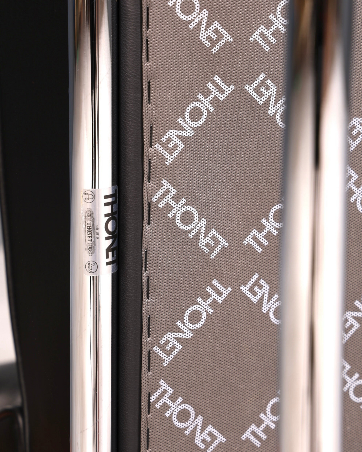 Hauptstadt Möblerei Thonet Stuhl mit grauem Stoffbezug und verchromtem Metallrahmen im Detail