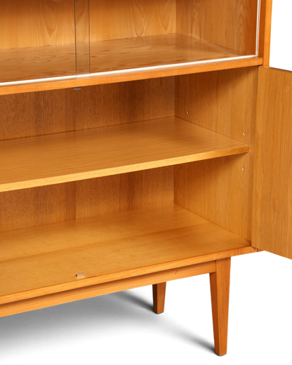 Hauptstadt Möblerei Vitrinenschrank aus hellem Holz mit Glasfront und verstellbaren Einlegeböden im Mid-Century Design