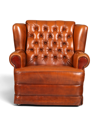 Hauptstadt Möblerei Chesterfield Sessel aus cognacfarbenem Echtleder mit klassischer Knopfheftung und Rollen