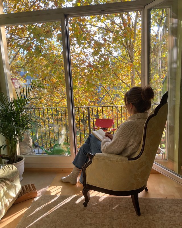 Customer reading in an armchair by an open window